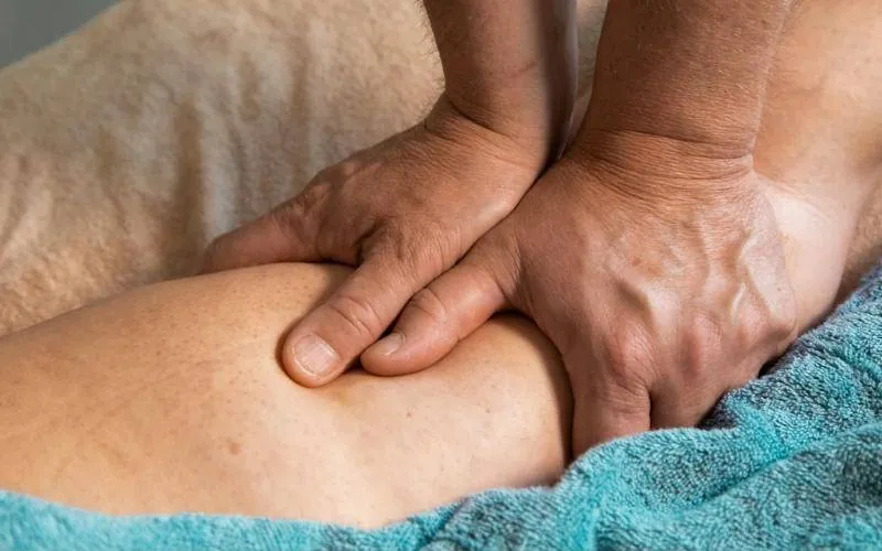 Hands working on a leg muscle during a sport massage